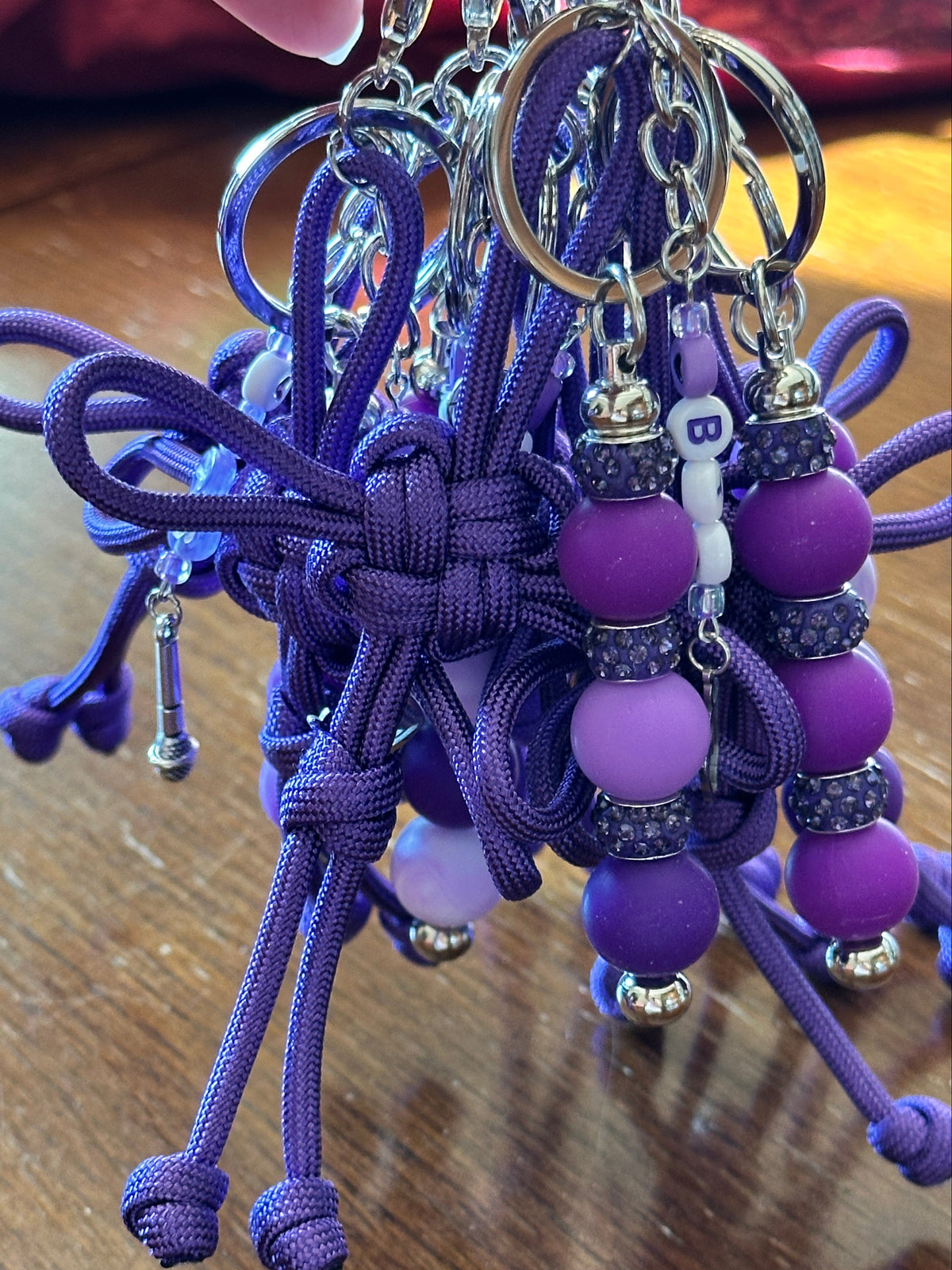 Dongsimgyol Knot, each made by hand, with a cluster of purple beads and charms on metal key ring.
